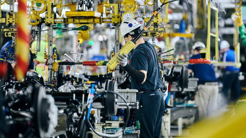An employee at Toyota builds large machinery