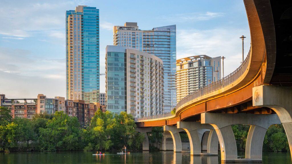 Highrise buildings look over a riverfront in Austin, Texas