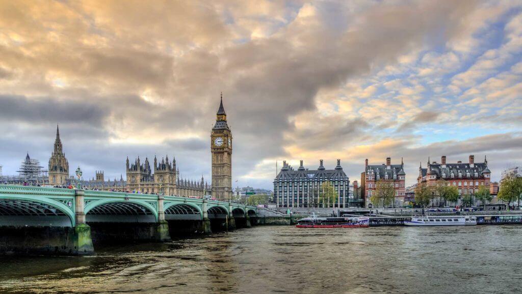Big Ben tower looking out over the Thames River and Westminster Bridge in London, England
