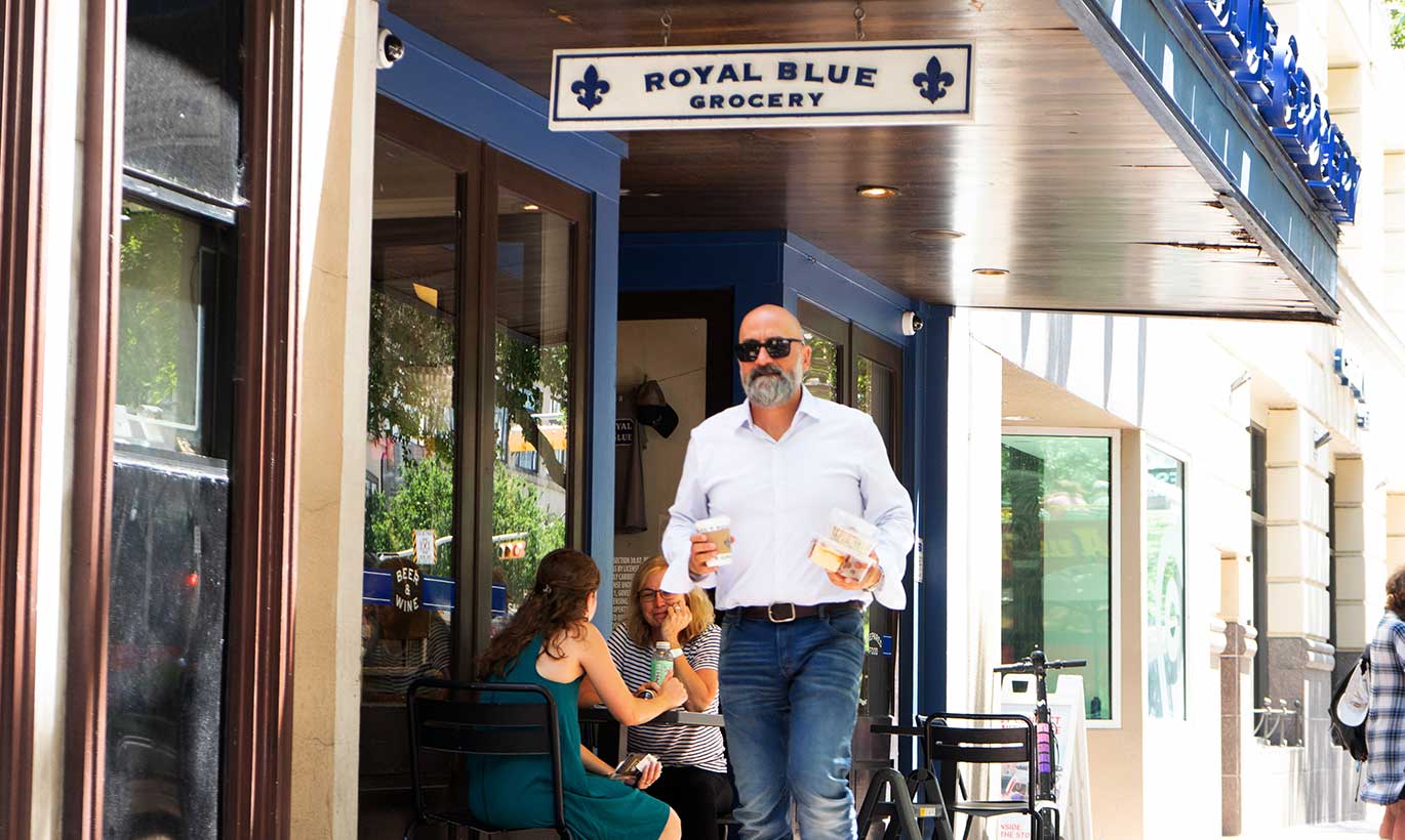 A man carries a coffee cup outside of Royal Blue Grocery in Austin, Texas.
