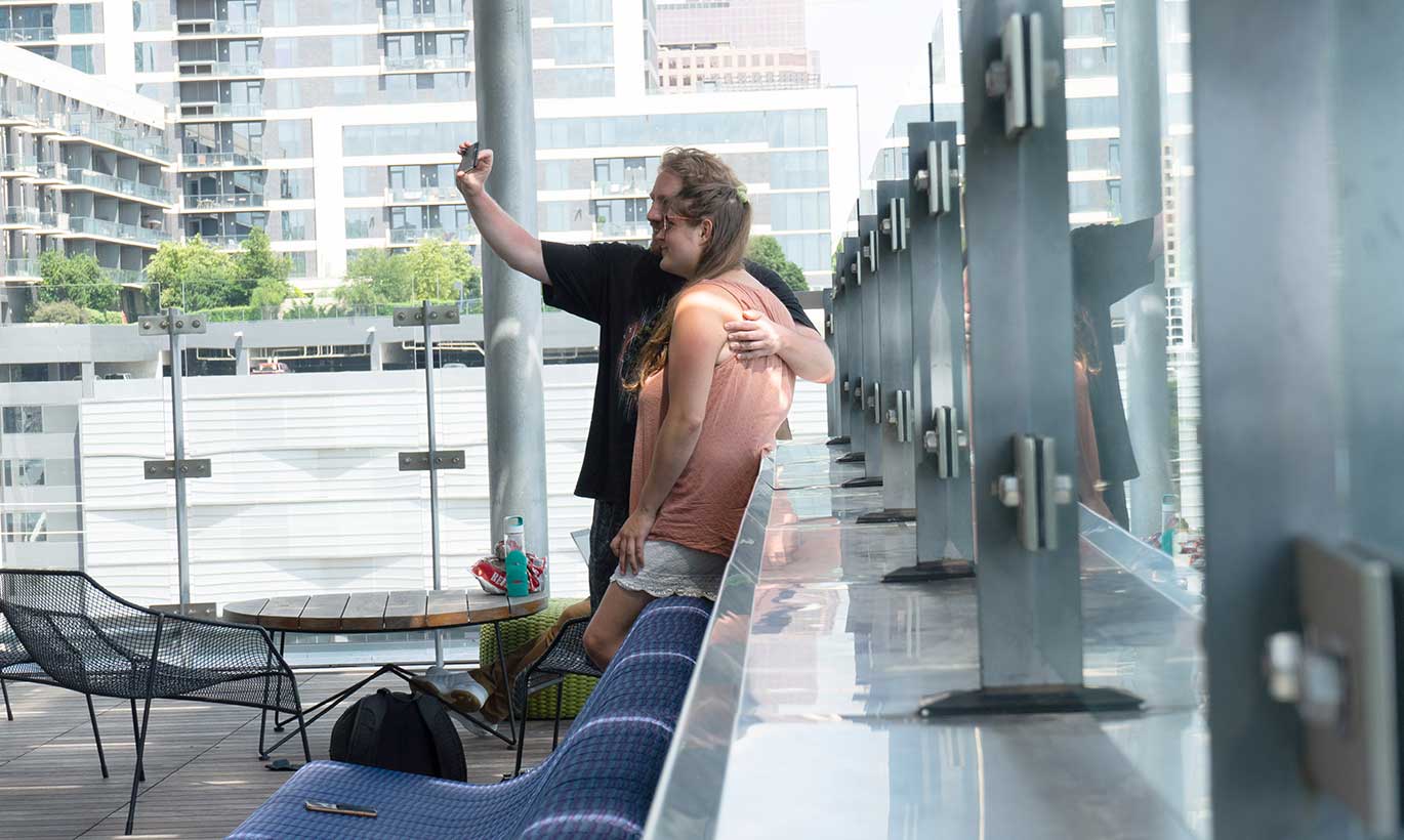 A man and woman take a selfie on the top floor of a building in Austin, Texas.