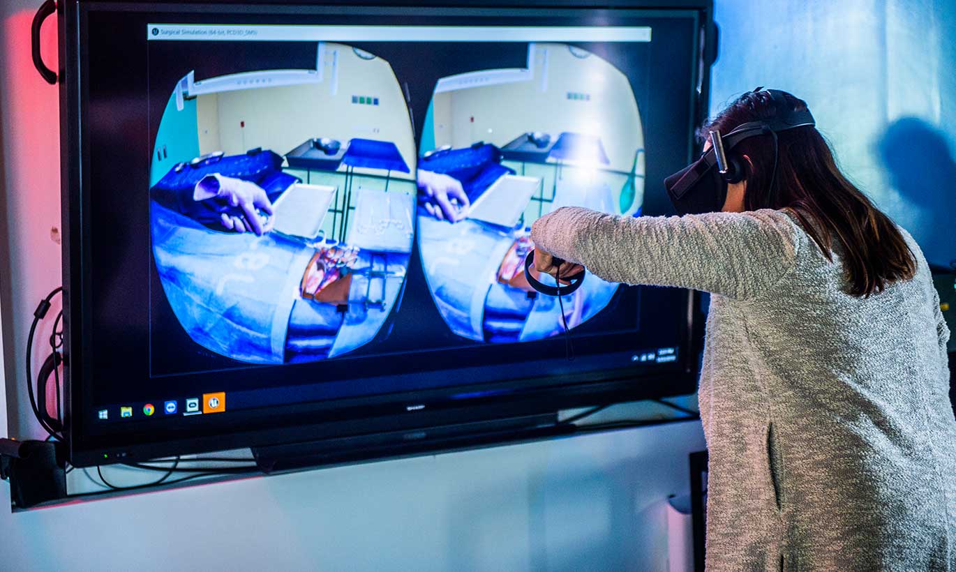 A woman wearing a headset tests a virtual reality device at Southern Methodist University.
