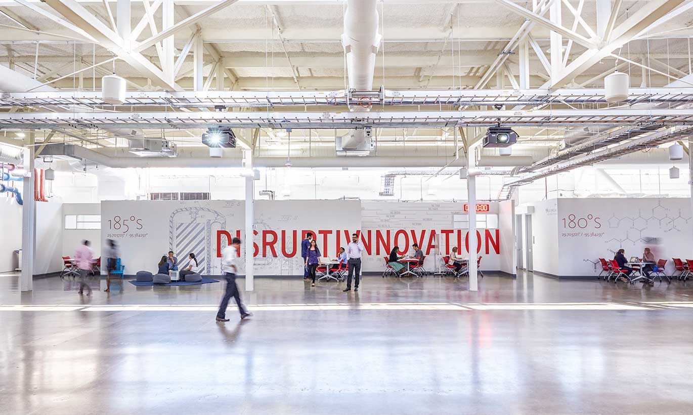 People walk through a large white room at Texas Medical Center, with the words 