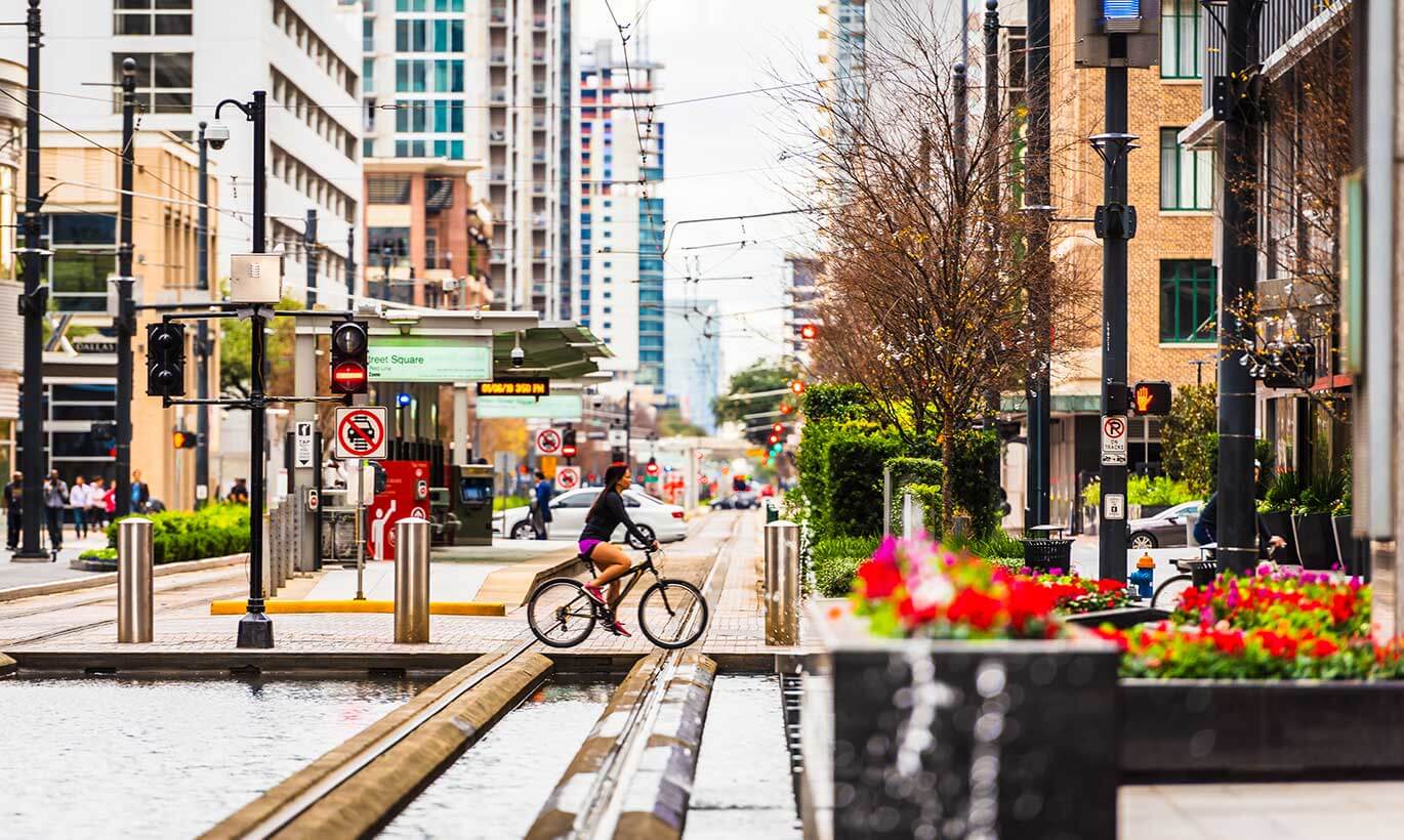 A woman rides a bicycle down main street in Houston, Texas.