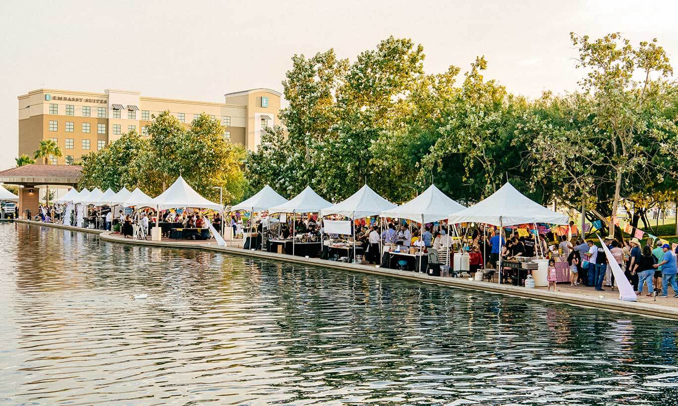 White tents serving food are lined up next to the riverfront in McAllen, Texas