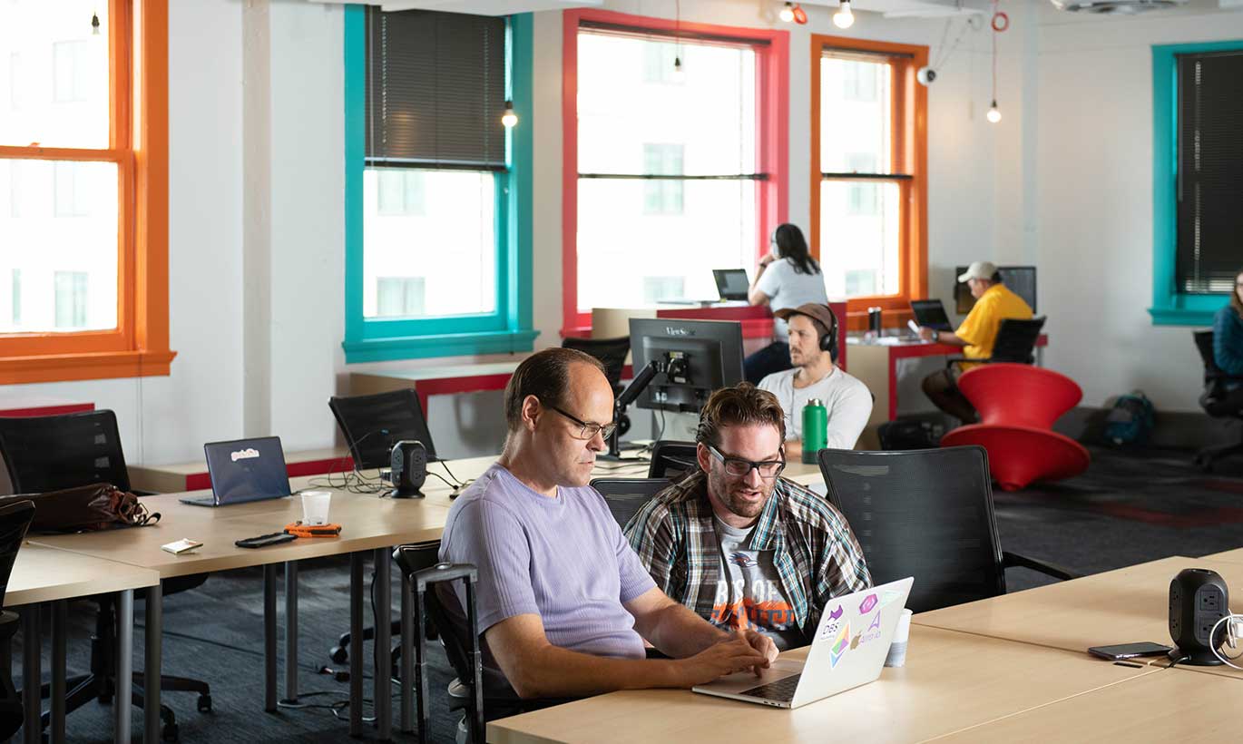Two men work on a laptop computer at the Geekdom Coworking Space in San Antonio, Texas