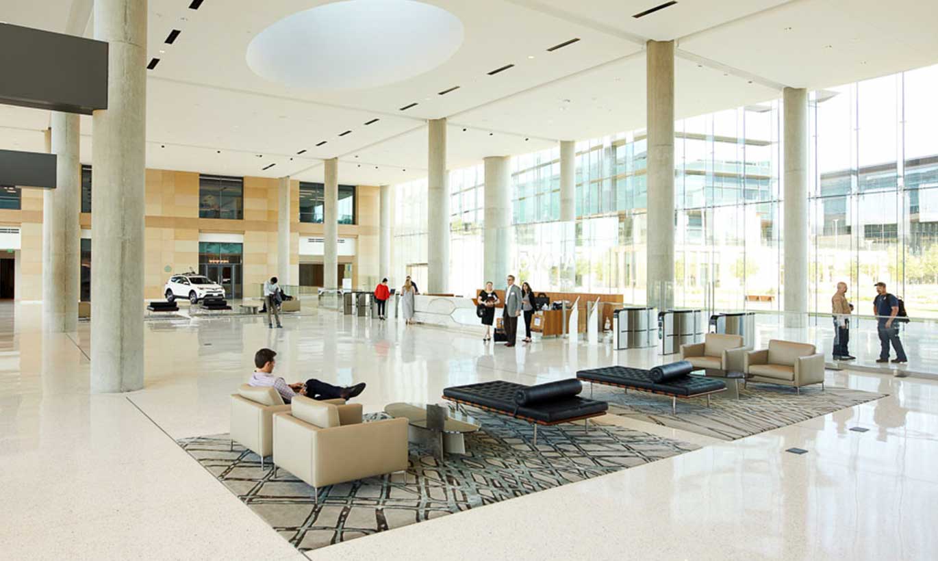 Business people walk through the Toyota open-concept lobby in Texas.