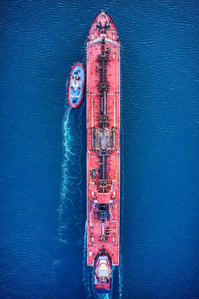 An aerial shot of a large cargo ship moving through the ocean